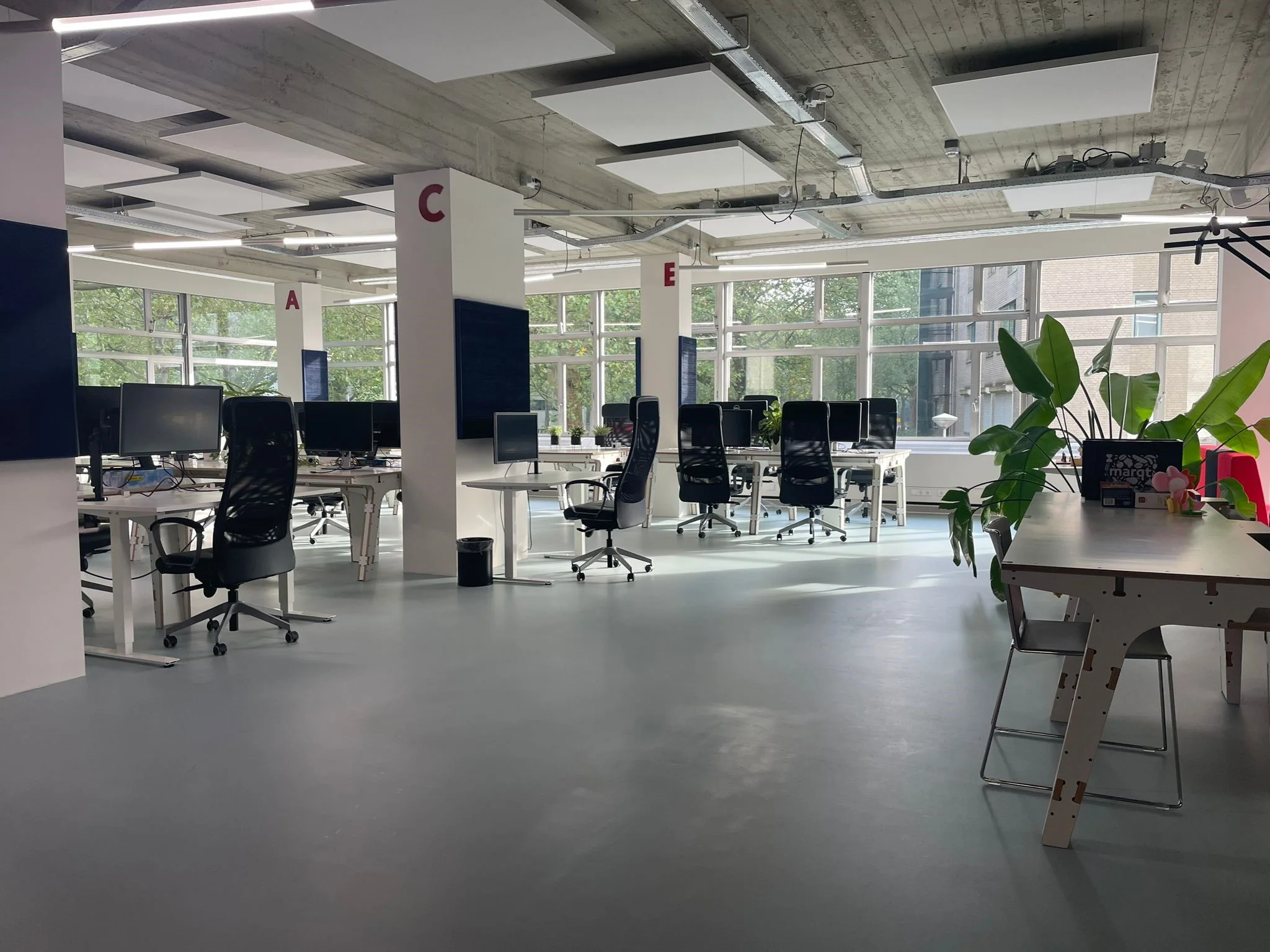 Moderne, open kantoorruimte aan de Van Leijenberghlaan met werkplekken, grote ramen en veel natuurlijk licht.